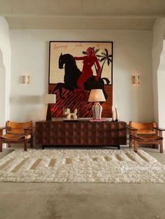 a living room filled with furniture and a painting on the wall