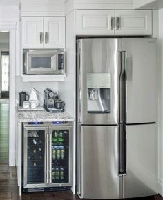 a stainless steel refrigerator freezer sitting inside of a kitchen next to a microwave oven