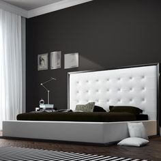 a black and white bedroom with an upholstered bed