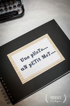 an open book sitting on top of a table next to a typewriter and pen