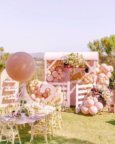 an outdoor party with balloons, tables and chairs