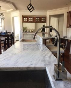 a large kitchen with marble counter tops and wooden cabinets in the back drop off area