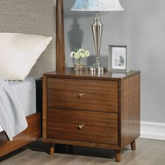 a night stand with two drawers and a lamp