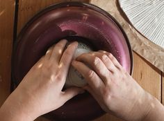 two hands on top of a purple object