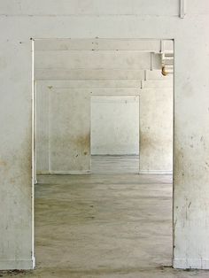 an empty room with white walls and wooden floors