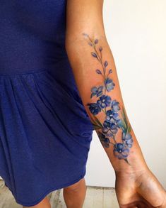 a woman's arm with blue flowers on it and the words, this floral ankle work