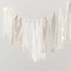 a white string with some lights hanging from it's sides and tassels attached to the strings