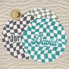 two round coasters with the word david printed on them in green and white checkers