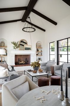 a living room filled with furniture and a fire place in the middle of a room