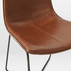 a brown leather chair with black metal legs