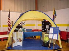 a tent set up in the middle of a room with tables and flags on it