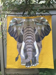 an elephant quilt hanging on a fence