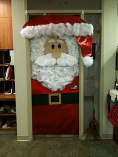 a door decorated like santa clause with red and white decorations on the front, standing in a hallway