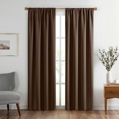 a living room with white walls and brown curtains