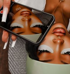 a woman holding up a cell phone with an image of her face on it