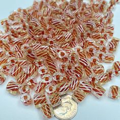 orange and white striped glass beads on a coin