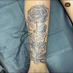 a woman's leg with a rose and cross tattoo on it