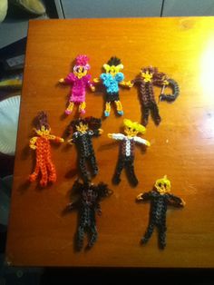 several small knitted figures on a wooden table