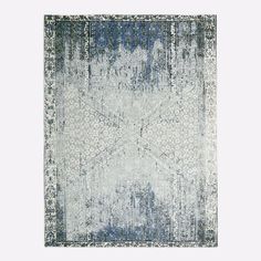 a blue and white area rug with an abstract design on the bottom, in front of a light gray background