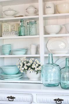 there is a white shelf with dishes and vases on it that says love the two different colours of this collection