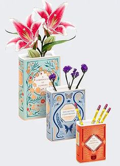 three vases with flowers and pencils in them