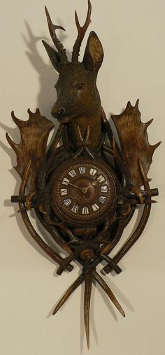 a deer head clock mounted to the side of a wall