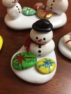 small snowmen sitting on top of white rocks