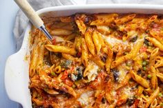 a white casserole dish filled with pasta and vegetables