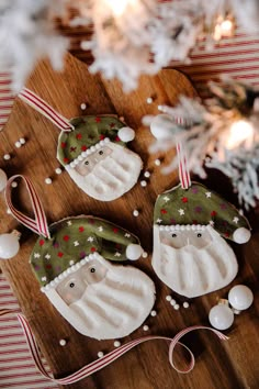 three decorated christmas ornaments on a wooden board