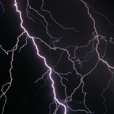 lightning strikes in the night sky above an airplane