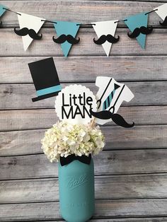 a little man centerpiece in a mason jar with hydrangeas and mustaches