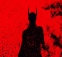 the shadow of a demon standing in front of a red background