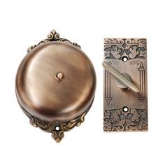 a door handle with a decorative design on the front and back side, next to an ornate brass plate