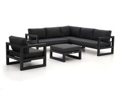 a black couch and chair sitting next to each other on a white floor with an ottoman