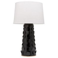 a black and white table lamp with a white shade on the top, sitting next to a light bulb