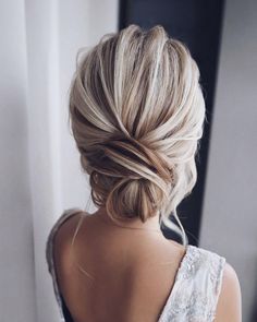 the back of a woman's head with blonde hair styled into a low bun