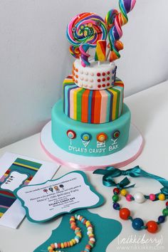 there is a multi - colored cake with candy on the top and other items around it