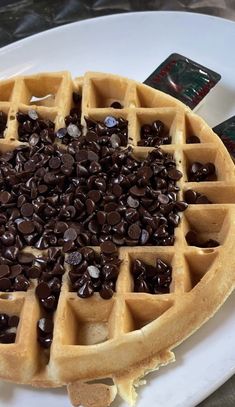 a waffle topped with chocolate chips on a white plate