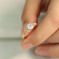 a woman's hand holding a diamond ring