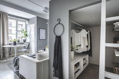 an open closet with clothes on hangers and other items in the room next to it