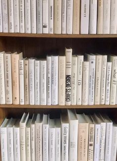 a book shelf filled with lots of books on top of wooden shelves next to each other