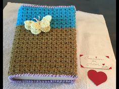 a crocheted book with a butterfly on it and a tag attached to the cover