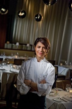 a woman standing next to a table in a restaurant