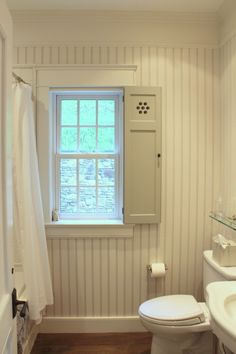 a bathroom with a sink, toilet and bathtub next to a window in the wall