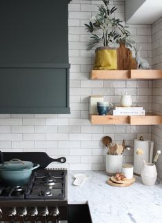 a stove top oven sitting inside of a kitchen next to shelves filled with pots and pans