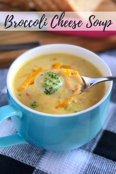 broccoli cheese soup in a blue bowl with a spoon and bread on the side