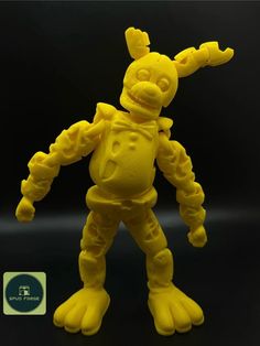 a yellow plastic toy that looks like an alien with arms and legs, standing in front of a black background