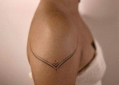 a woman's shoulder with a small tattoo on the left side of her arm