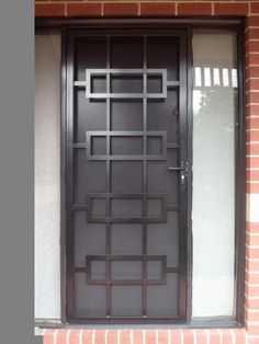 a brick building with an iron door and window frame on the outside, next to a fire hydrant