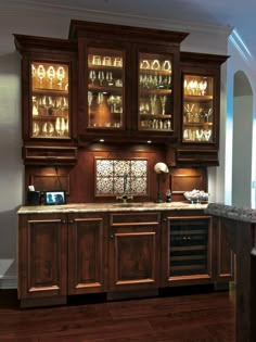 a kitchen with wooden cabinets and marble counter tops, along with dark wood flooring